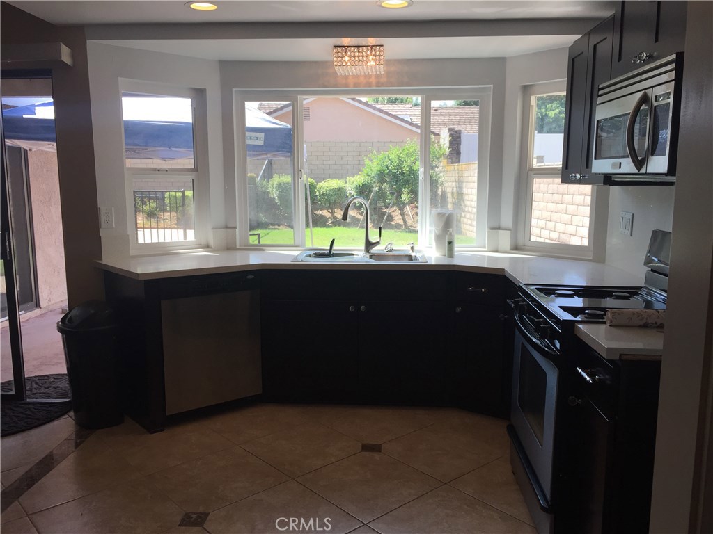 50 Village Loop Road Phillips Ranch, CA 91766 - Photo 13 of 48 a kitchen with a sink stove and microwave