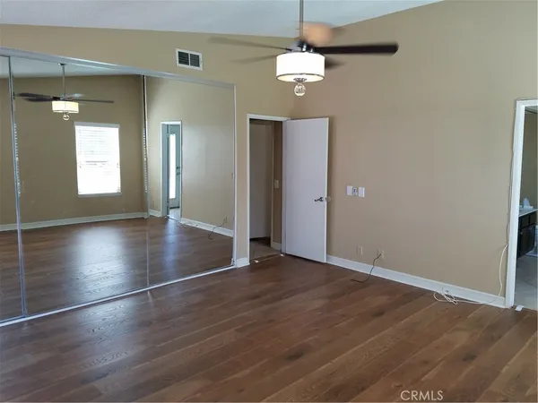 an empty room with wooden floor and mirror