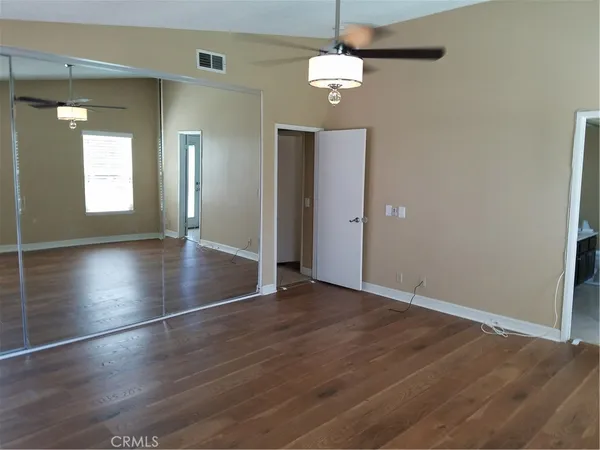 an empty room with wooden floor and chandelier