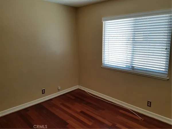 a view of a room with wooden floor and a window