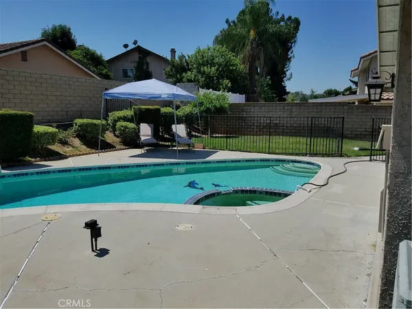 a view of a backyard with table and chairs under an umbrella