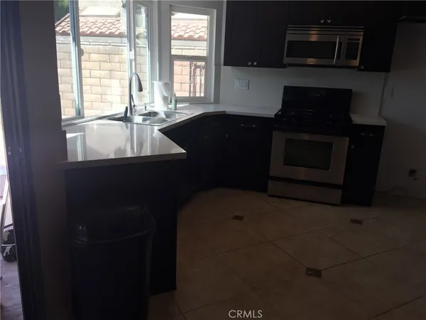 a kitchen with a sink a stove and microwave