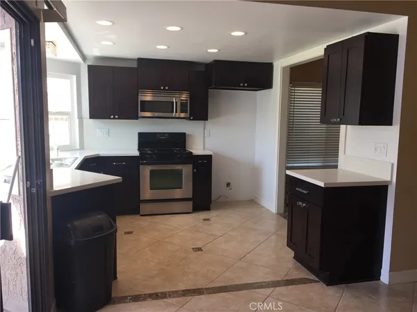 a kitchen with stainless steel appliances kitchen island granite countertop a stove a sink and a refrigerator