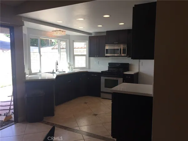 a kitchen with stainless steel appliances a sink stove and microwave