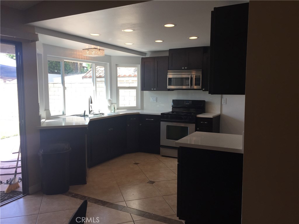50 Village Loop Road Phillips Ranch, CA 91766 - Photo 9 of 48 a kitchen with stainless steel appliances a sink stove and microwave