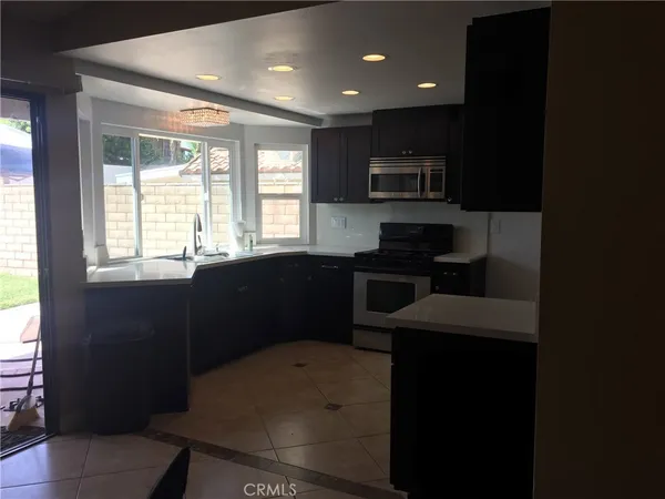 a kitchen with a sink wooden cabinets and black appliances