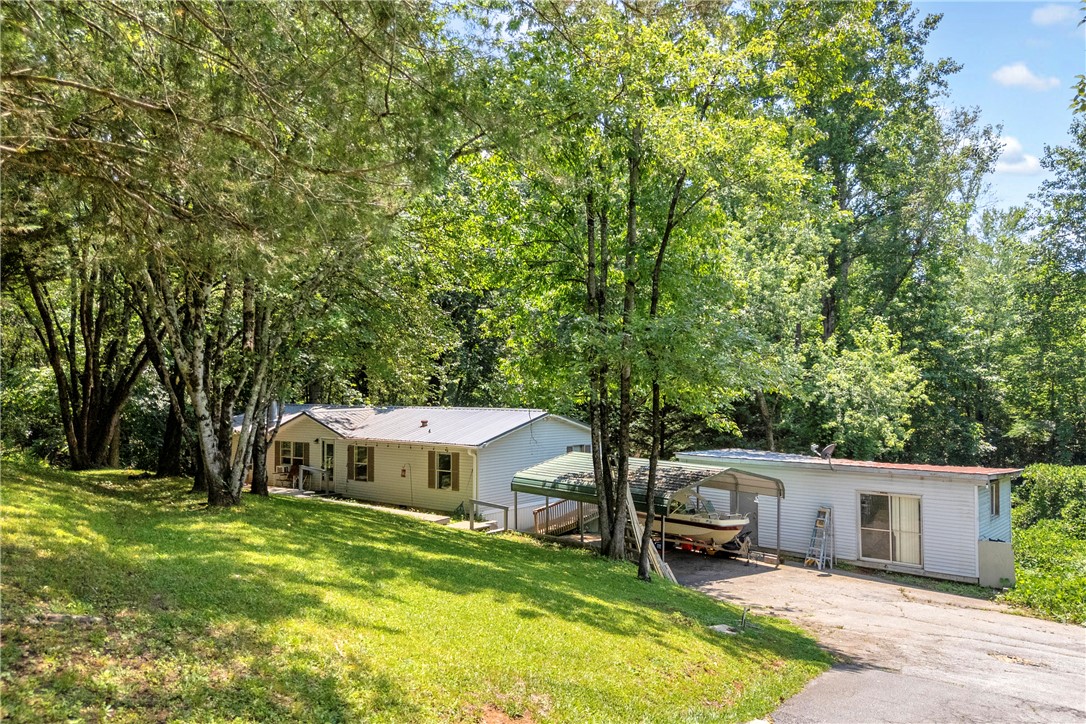 162 Newberry Road Walhalla, SC 29691 - Photo 2 of 50 A verdant hillside cradles this cozy home, offering a serene, private retreat amidst towering trees.