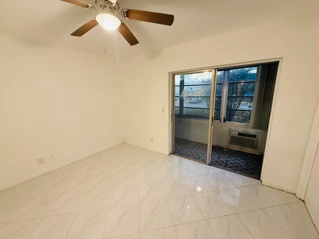 an empty room with chandelier fan