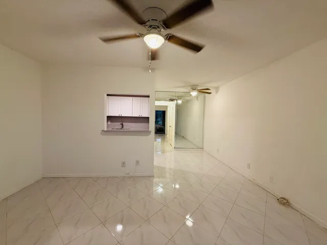 en empty room with ceiling fan and window