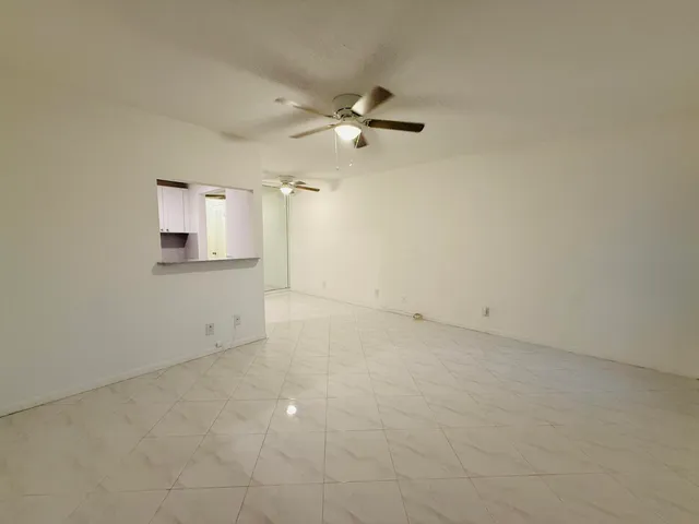 an empty room with a bathroom and a ceiling fan