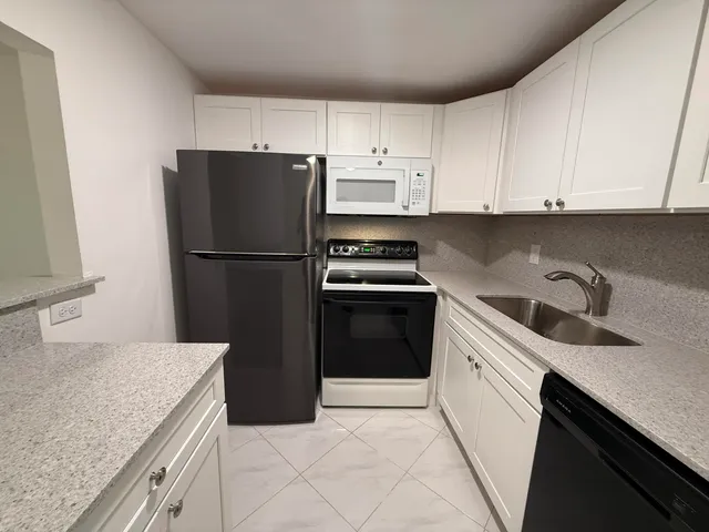 a kitchen with a sink a refrigerator and cabinets