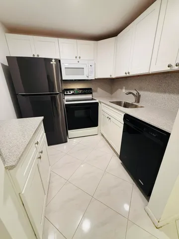 a kitchen with a sink and white stainless steel appliances