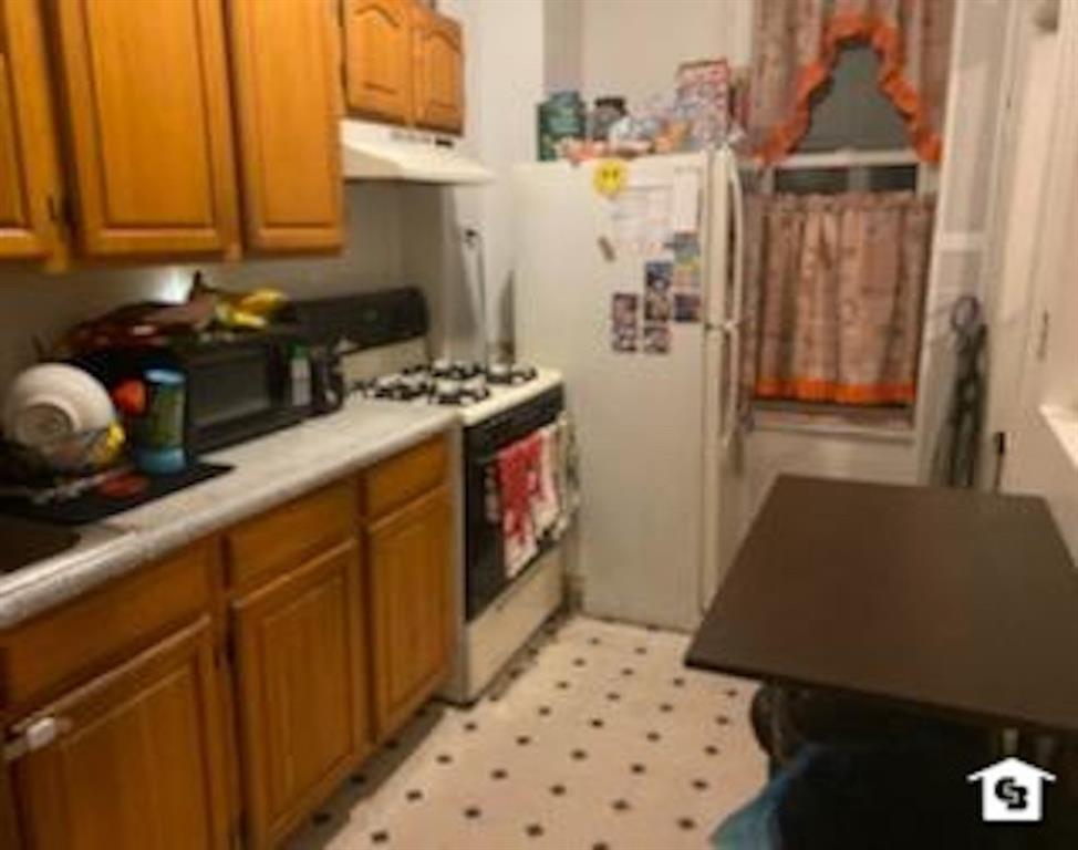 7608 3rd Avenue Brooklyn, NY 11209 - Photo 5 of 12 a kitchen with a refrigerator and a stove