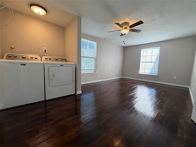 a view of a livingroom with wooden floor and a ceiling fan