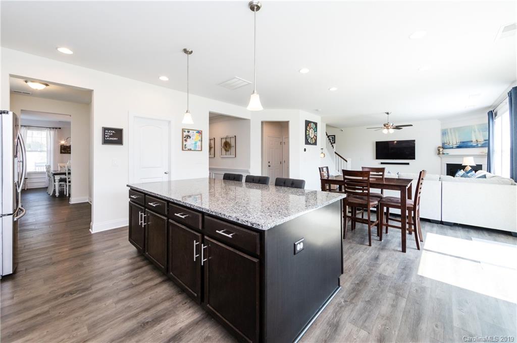 213 Morgan's Branch Road Belmont, NC 28012 - Photo 16 of 41 a kitchen with stainless steel appliances granite countertop a stove top oven a sink dishwasher a dining table and chairs with wooden floor