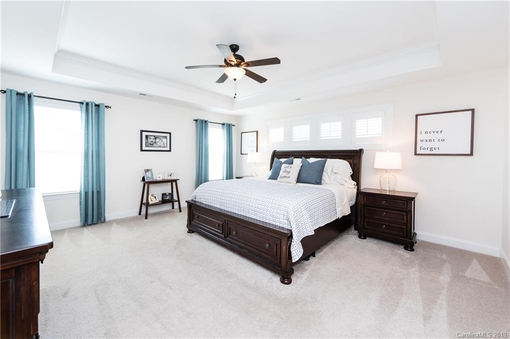 213 Morgan's Branch Road Belmont, NC 28012 - Photo 22 of 41 a bedroom with a bed and a chandelier