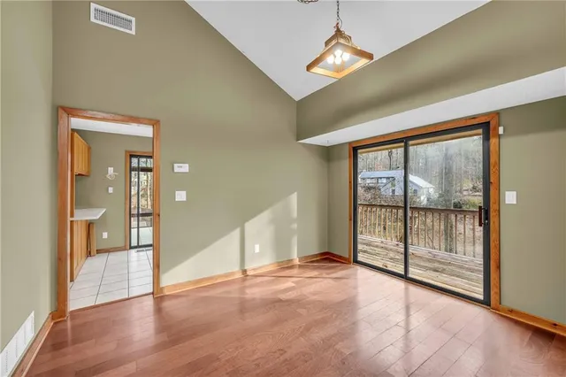 a view of empty room with wooden floor and balcony