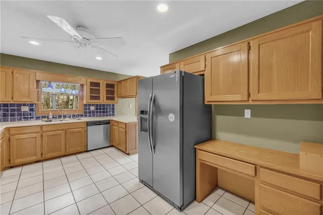 a kitchen with a refrigerator sink and cabinets