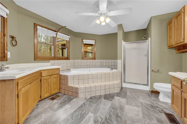 a spacious bathroom with a double vanity sink a mirror a bathtub and next to a window