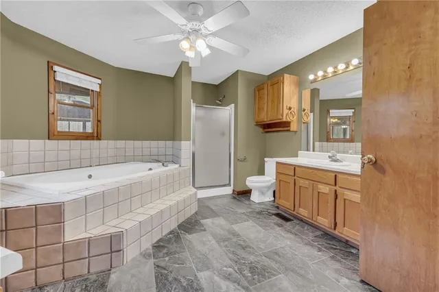 a spacious bathroom with a granite countertop tub sink and mirror