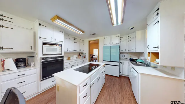 a kitchen with granite countertop a refrigerator stove top oven and sink