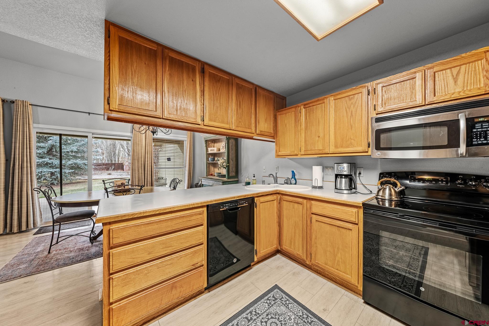 780 Waterfall Lane Durango, CO 81301 - Photo 13 of 35 a kitchen with granite countertop wooden cabinets stainless steel appliances and a window