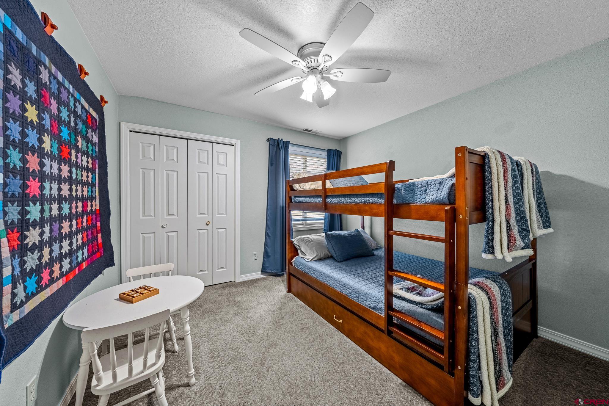780 Waterfall Lane Durango, CO 81301 - Photo 22 of 35 a bedroom with furniture and a chandelier