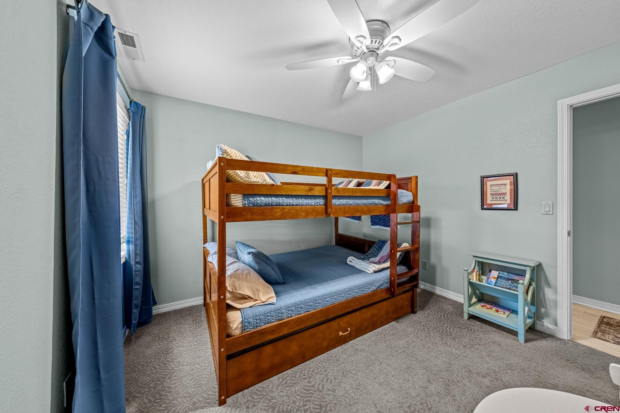 780 Waterfall Lane Durango, CO 81301 - Photo 23 of 35 a bedroom with furniture and a chandelier fan
