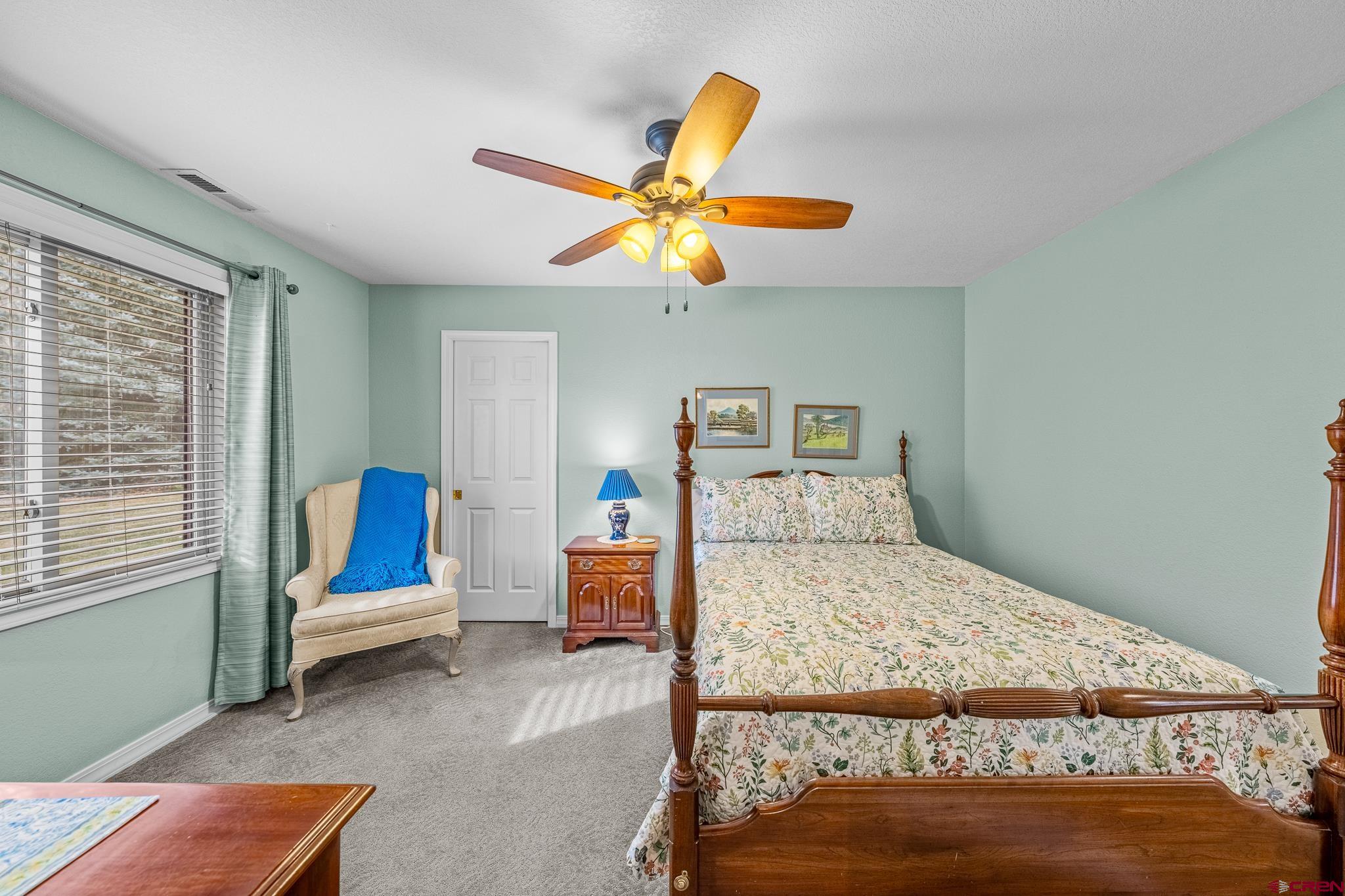 780 Waterfall Lane Durango, CO 81301 - Photo 28 of 35 a bedroom with a bed and a chandelier