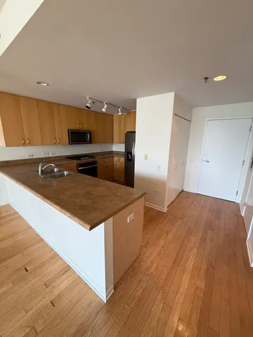 a kitchen with stainless steel appliances granite countertop a sink a stove a refrigerator and cabinets