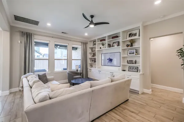 a kitchen with stainless steel appliances kitchen island granite countertop a sink dishwasher stove and white cabinets with wooden floor