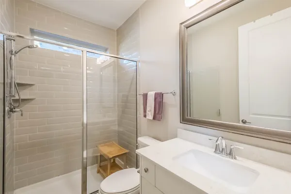 a bathroom with a sink a toilet and shower