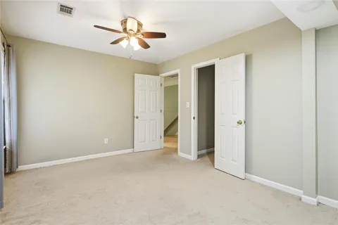 an empty room with closet and a chandelier fan