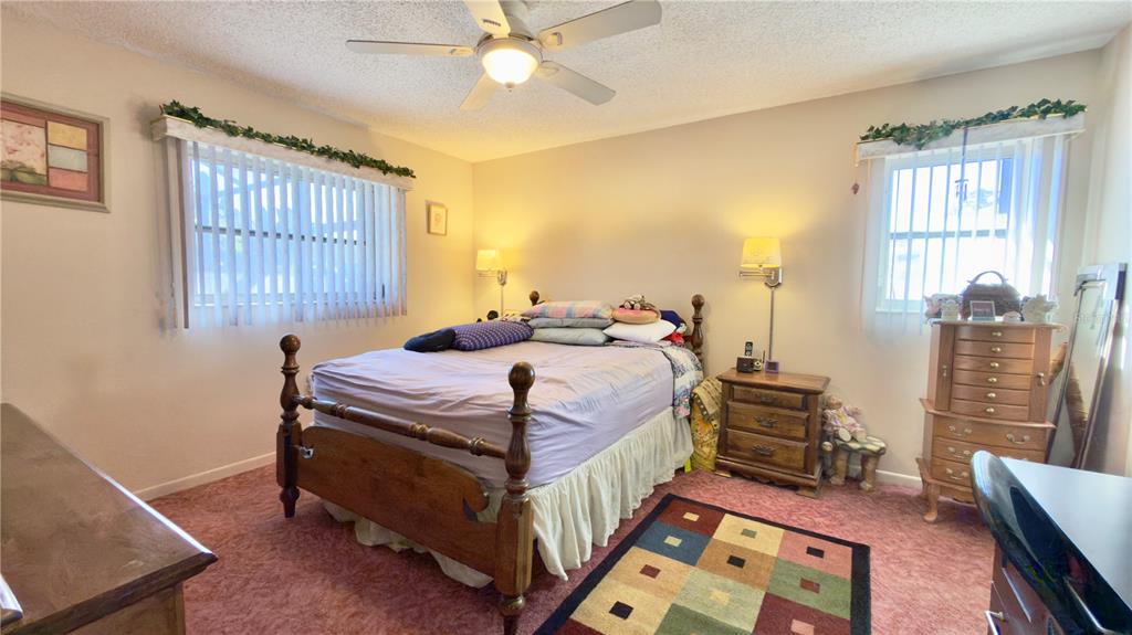 12985 116th Street Largo, FL 33778 - Photo 13 of 28 a bedroom with a bed a dresser next to a window