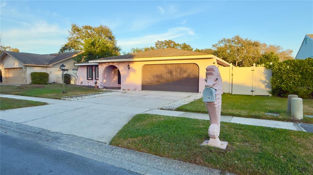 12985 116th Street Largo, FL 33778 - Photo 2 of 28 a front view of a house with a yard and garage