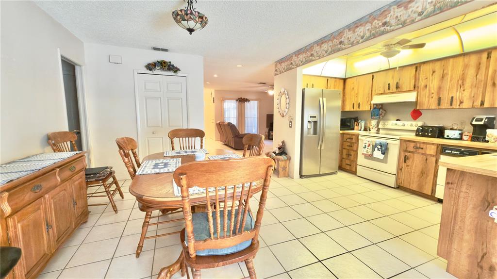 12985 116th Street Largo, FL 33778 - Photo 6 of 28 a view of a dining room with furniture a chandelier and kitchen view