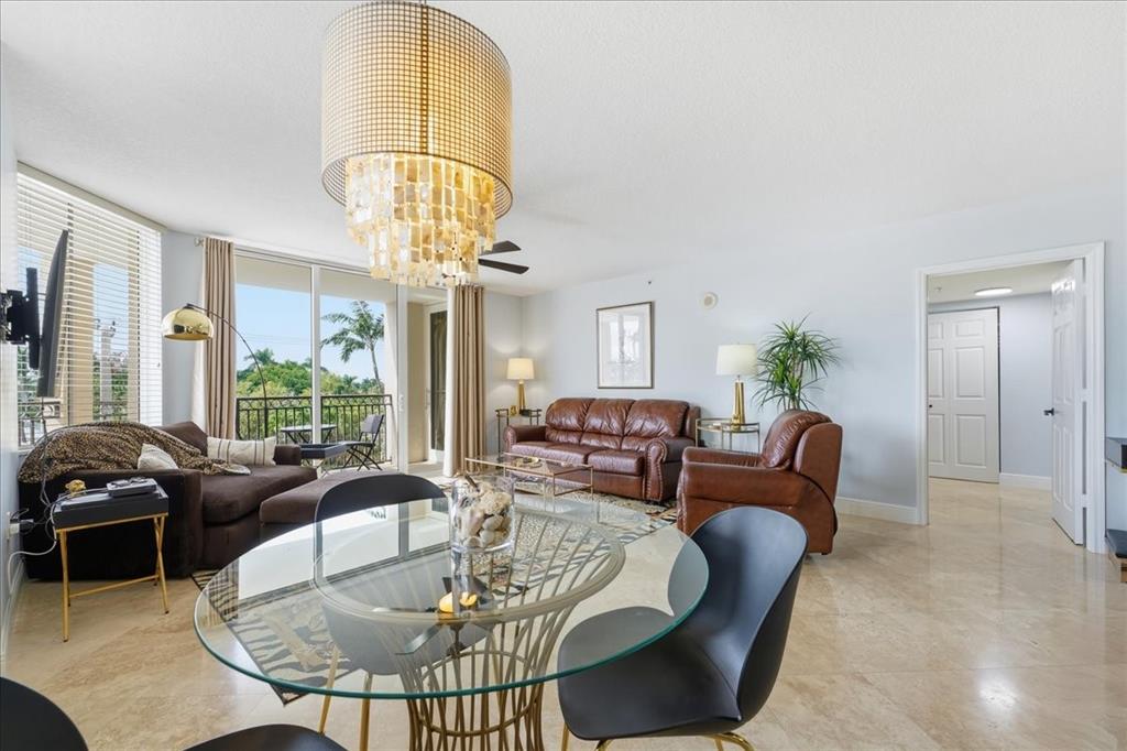 2011 North Ocean Boulevard, Unit 302 Fort Lauderdale, FL 33305 - Photo 11 of 45 a living room with furniture a chandelier and a large window