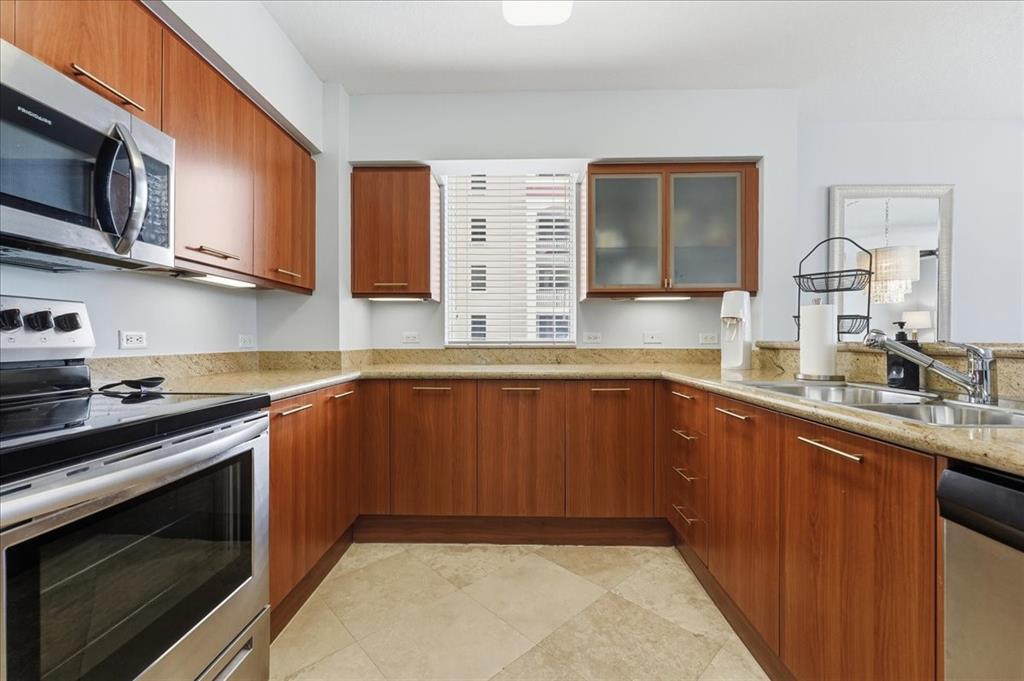 2011 North Ocean Boulevard, Unit 302 Fort Lauderdale, FL 33305 - Photo 15 of 45 a kitchen with stainless steel appliances granite countertop a sink stove and microwave