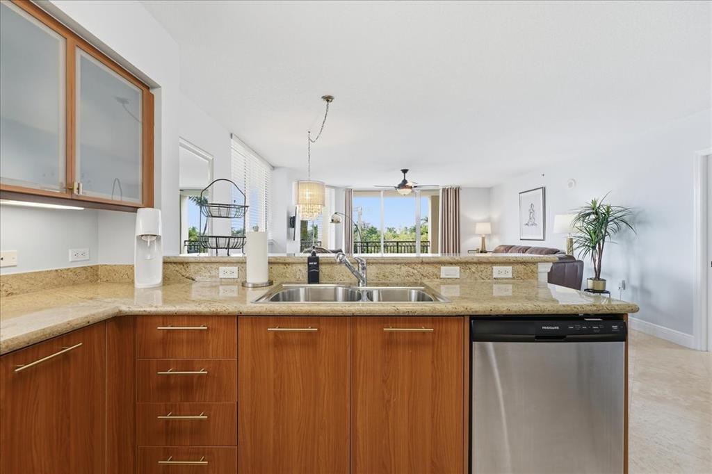 2011 North Ocean Boulevard, Unit 302 Fort Lauderdale, FL 33305 - Photo 16 of 45 a kitchen with granite countertop a sink a counter top space and cabinets