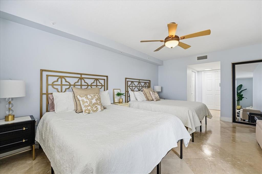 2011 North Ocean Boulevard, Unit 302 Fort Lauderdale, FL 33305 - Photo 22 of 45 a bedroom with a bed and a chandelier