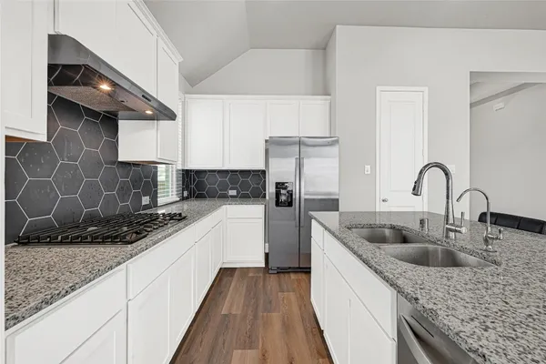 a kitchen with stainless steel appliances granite countertop a sink stove and refrigerator