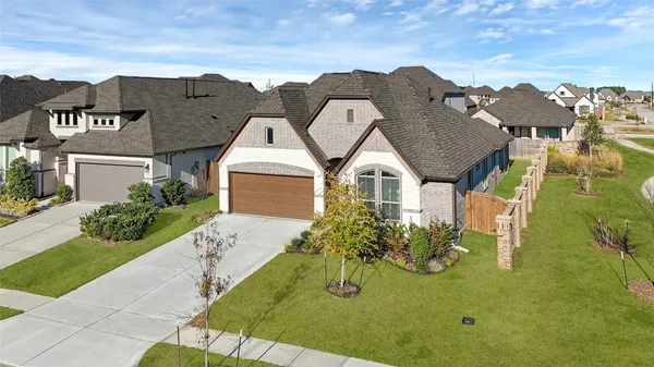a view of a big house with a big yard and potted plants