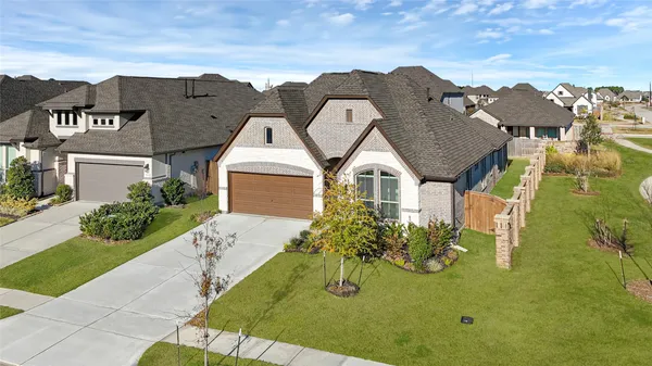 a view of a big house with a big yard and potted plants
