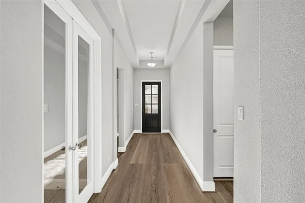 a view of a hallway with wooden floor and staircase