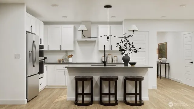 a kitchen with stainless steel appliances a sink a stove a refrigerator and center island