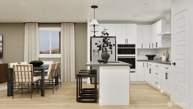 a kitchen with stainless steel appliances kitchen island granite countertop a table chairs and a refrigerator