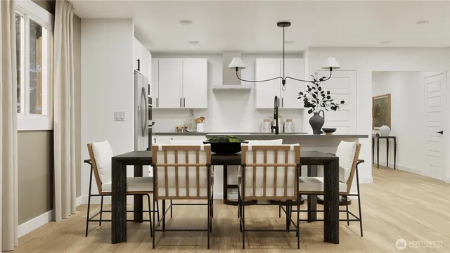 a kitchen with stainless steel appliances kitchen island granite countertop a dining table chairs and a refrigerator