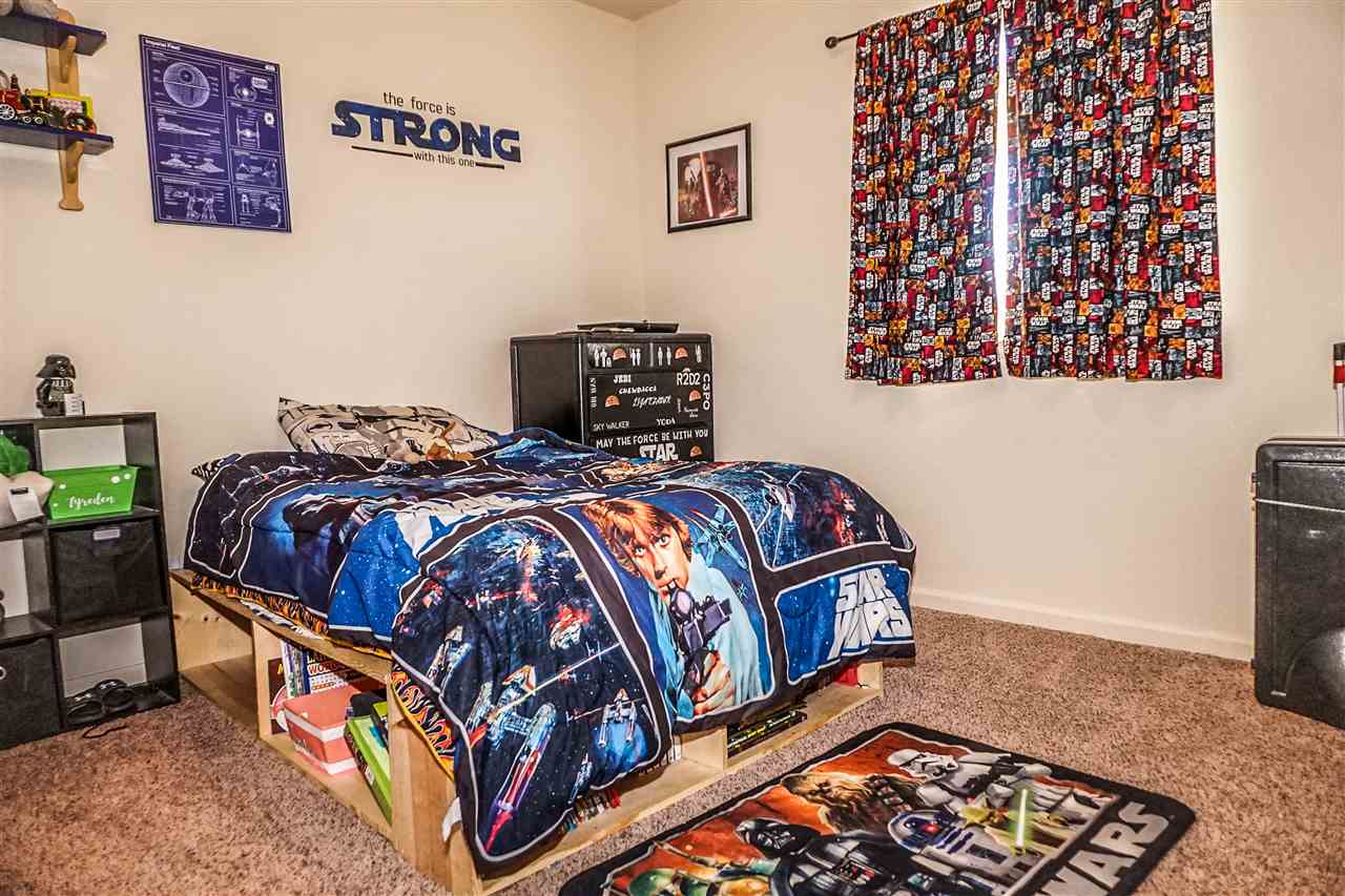 1860 Golden Ranch Road Fruita, CO 81521 - Photo 16 of 27 a bed sitting in a bedroom next to a window with wooden floor