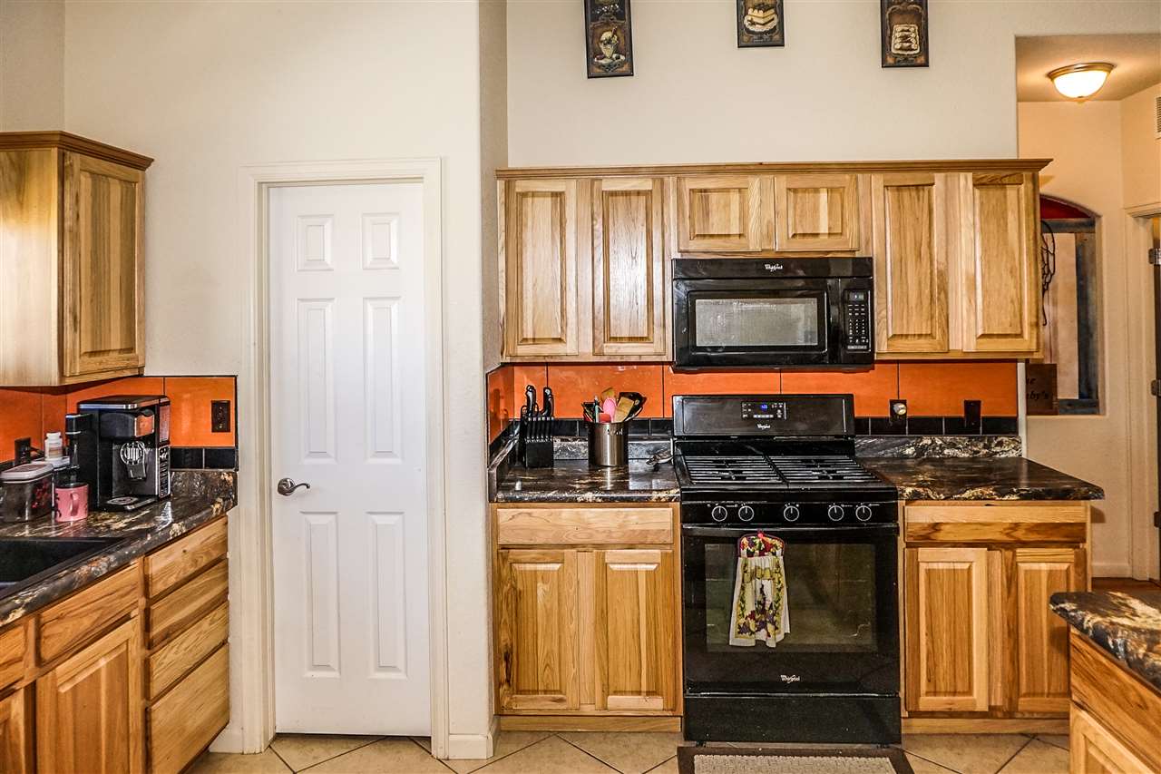 1860 Golden Ranch Road Fruita, CO 81521 - Photo 7 of 27 a kitchen with stainless steel appliances granite countertop a stove top oven a refrigerator a sink and dishwasher with wooden floor