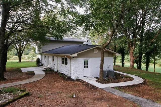 an empty room with wooden floor chandelier fan and windows